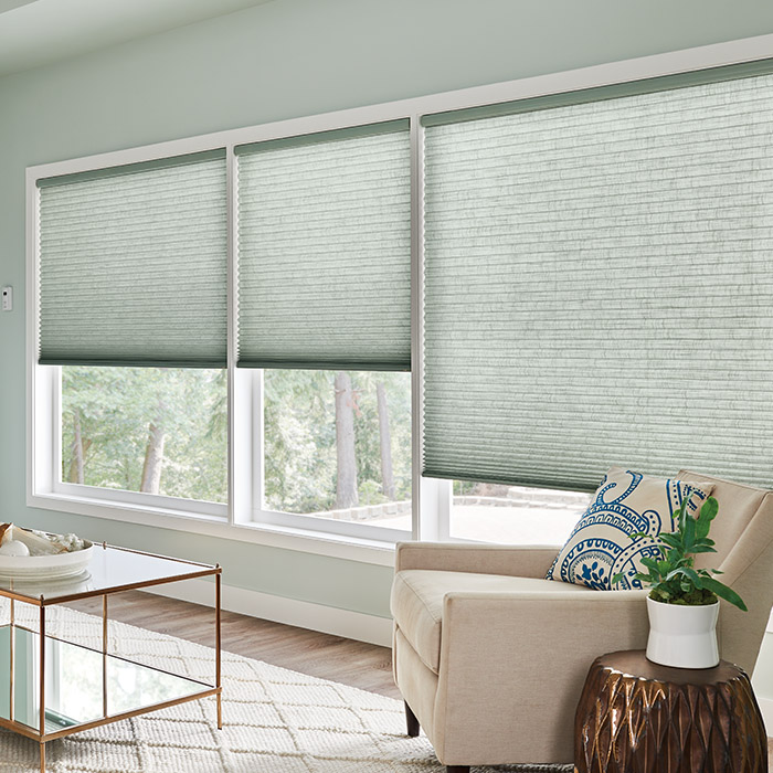 Green sage cellular motorized shades inside a living room.