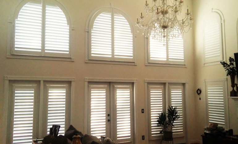 TV room in open concept Virginia Beach house with plantation shutters on high windows.